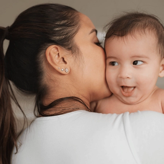 Mum kissing her baby