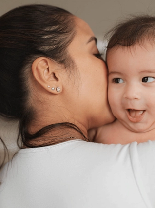 Mum kissing her baby
