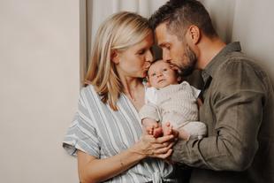 Mutter und Vater mit kleinem Baby in den Armen