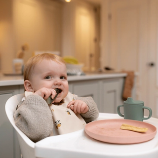 Baby snacking on cucumber stick