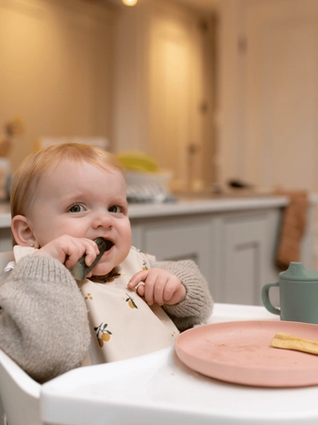 Baby snacking on cucumber stick