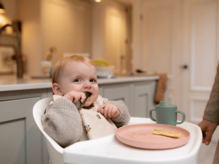 Baby snacking on cucumber stick