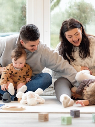 Mum and dad in living room with baby