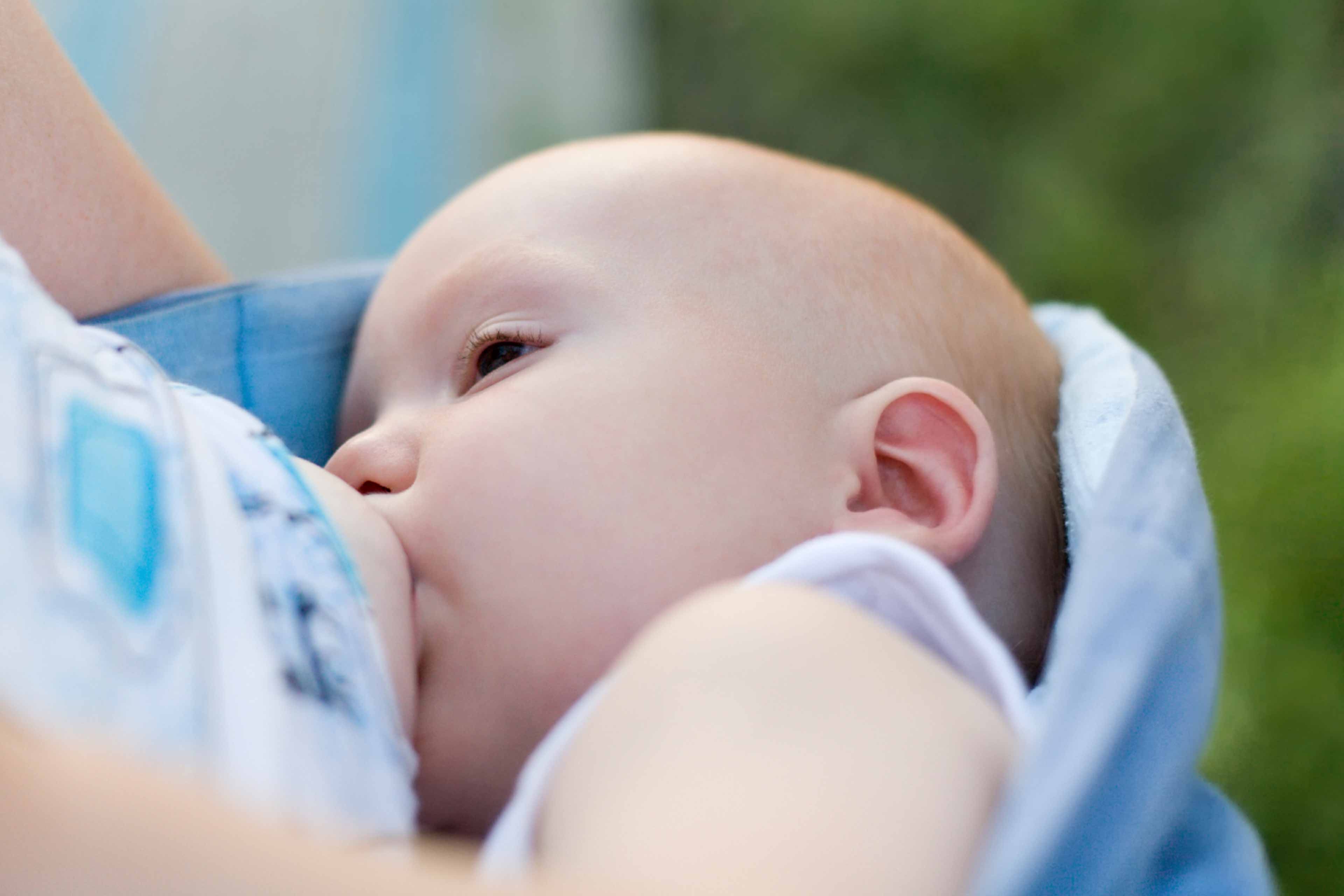 Ein Baby, das scheinbar gerade gefüttert wird, wobei der Fokus auf seinem Gesichtsausdruck und der Umgebung liegt.