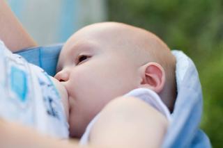 Ein Baby, das scheinbar gerade gefüttert wird, wobei der Fokus auf seinem Gesichtsausdruck und der Umgebung liegt.