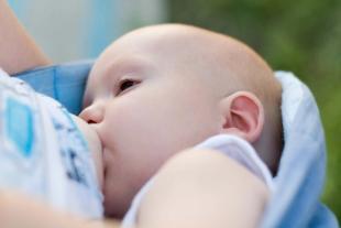 Ein Baby, das scheinbar gerade gefüttert wird, wobei der Fokus auf seinem Gesichtsausdruck und der Umgebung liegt.