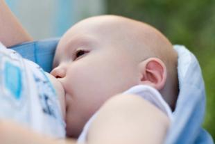 Ein Baby, das scheinbar gerade gefüttert wird, wobei der Fokus auf seinem Gesichtsausdruck und der Umgebung liegt.