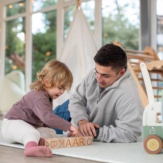 father and toddler playing on the floor.