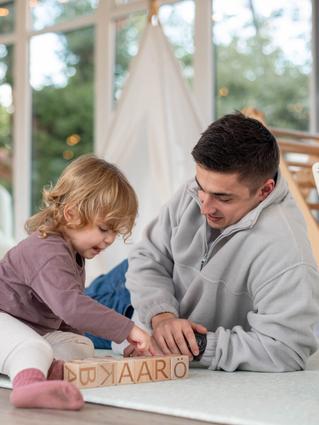 father and toddler playing on the floor.