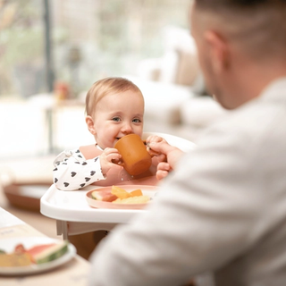 Baby drinking from beaker
