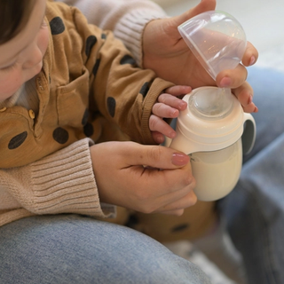 Mum preparing to bottle feed baby