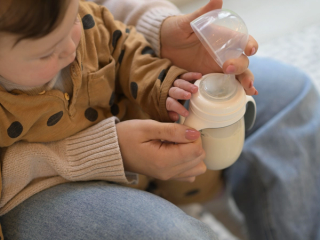 Mum preparing to bottle feed baby