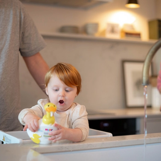 Toddler staring at the HiPP duck handwash with a shocked expression