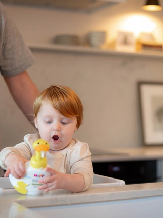 Toddler staring at the HiPP duck handwash with a shocked expression