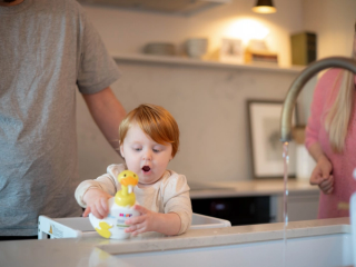Toddler staring at the HiPP duck handwash with a shocked expression