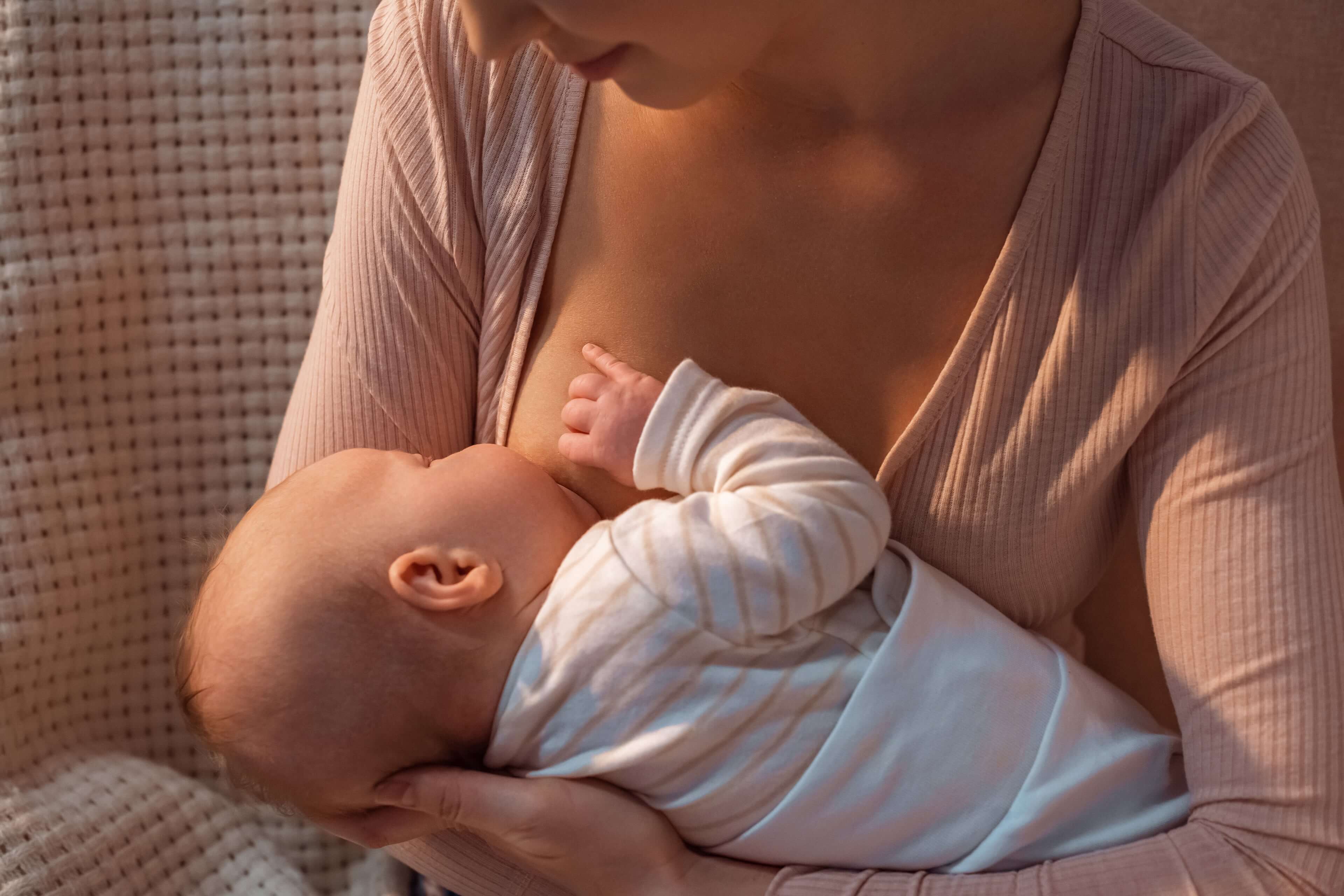 Eine Mutter hält und füttert sanft ihr Baby.