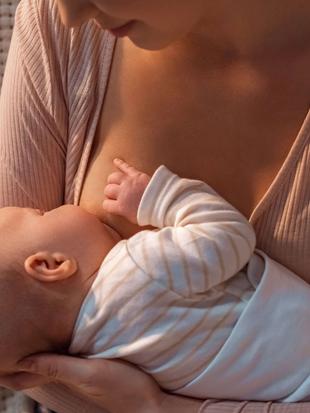 Eine Mutter hält und füttert sanft ihr Baby.