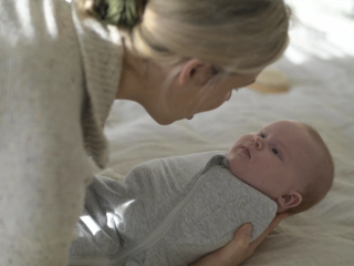Mum holding baby in swaddle