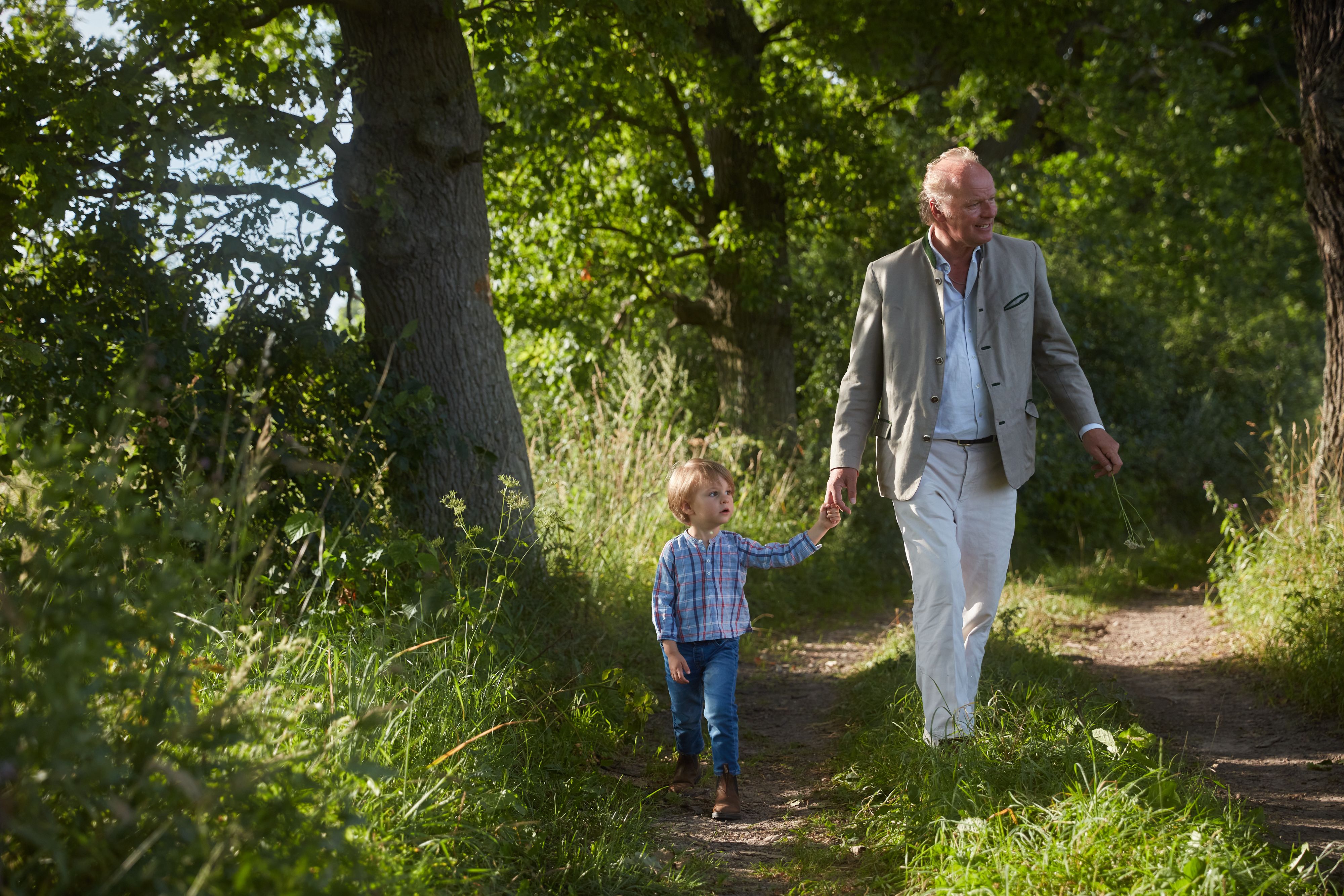 Stefan Hipp mit seinem Sohn in einer grünen Landschaft.