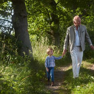 Stefan Hipp mit seinem Sohn in einer grünen Landschaft.