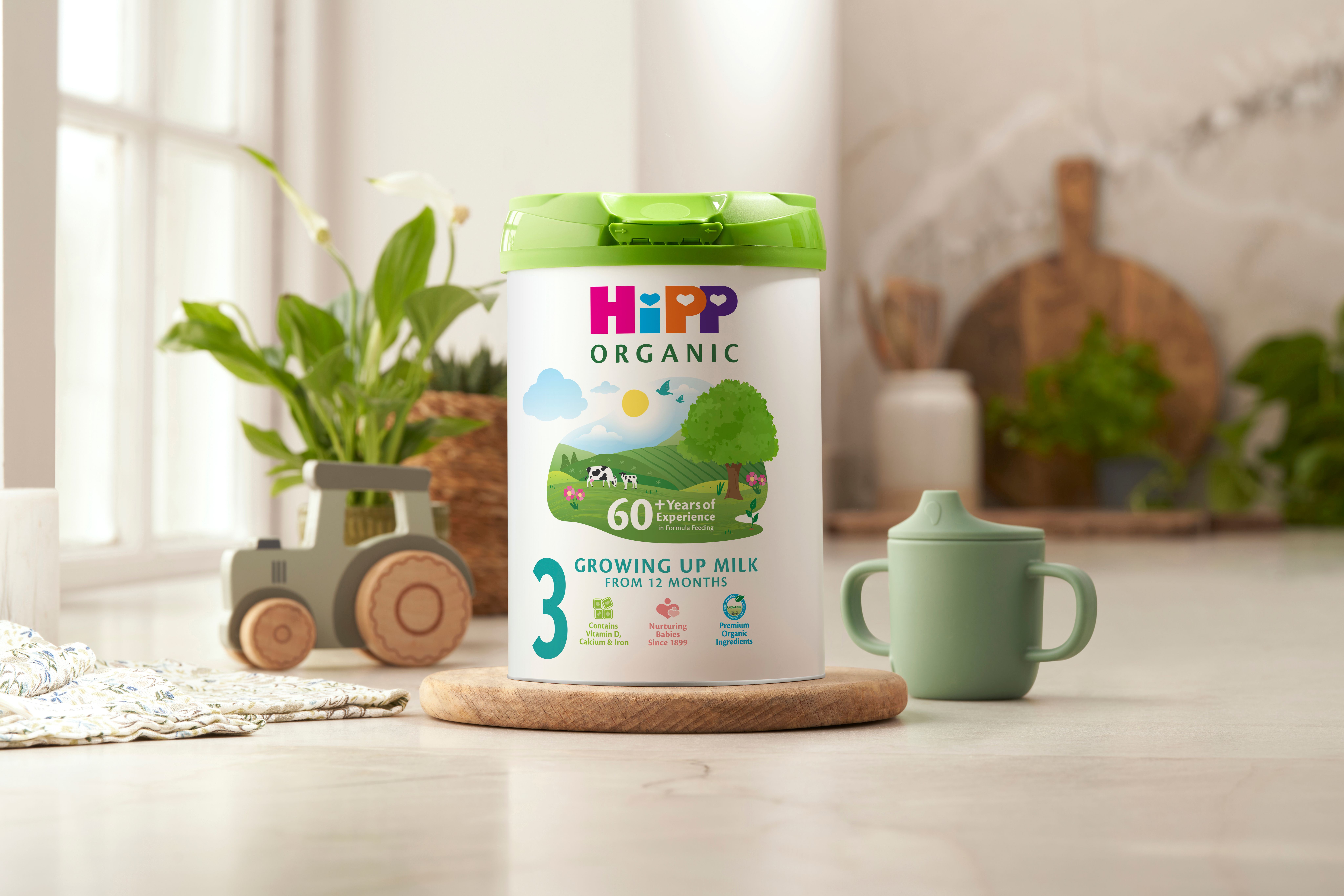 HiPP Organic growing up milk powder tin on a kitchen worktop next to a sippy cup