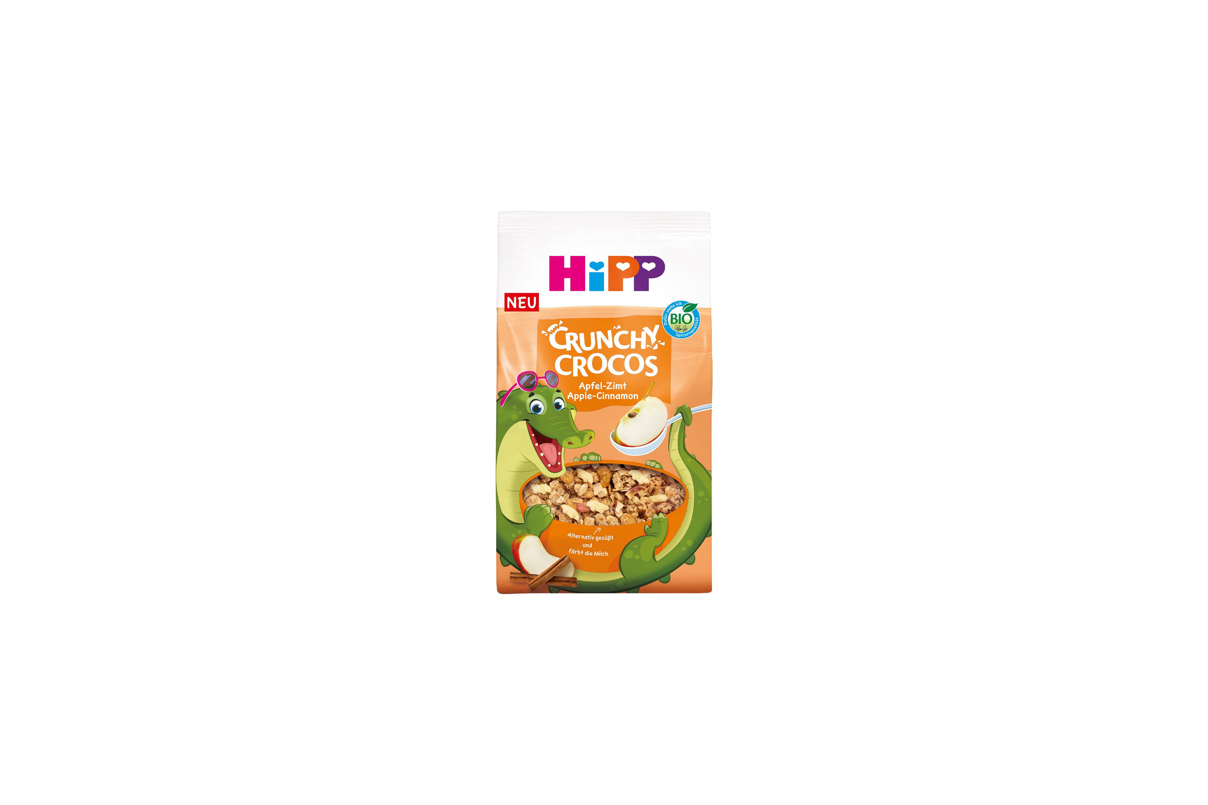 HiPP Crunchy Crocos Apfel-Zimt Bio-Kinder-Müsli mit fröhlichem Krokodil-Maskottchen auf orangefarbener Verpackung