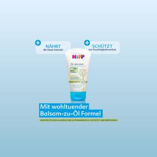 HiPP HOCHVERTRÄGLICH Öl-Balsam Tube vor blauem Hintergrund mit Claims: nährt intensiv, schützt vor Feuchtigkeitsverlust, Balsam-zu-Öl Formel