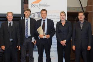 Fünf Personen im Anzug stehen vor EUROSOLAR-Roll-up, der HiPP Vertreter hält den Deutschen Solarpreis 2011 in den Händen.