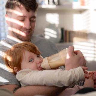 Dad bottle feeding baby