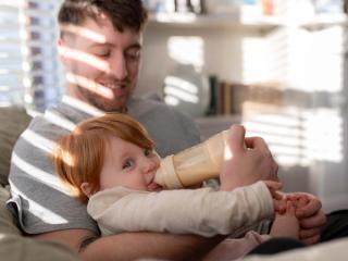 Dad bottle feeding baby