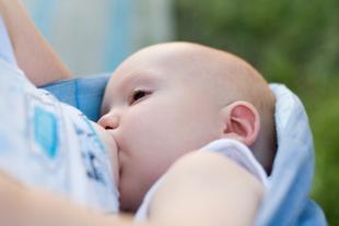 Ein Baby, das scheinbar gerade gefüttert wird, wobei der Fokus auf seinem Gesichtsausdruck und der Umgebung liegt.
