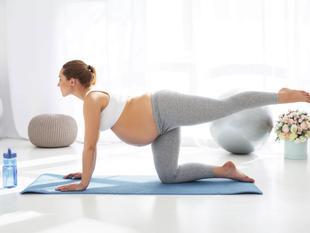 Eine Frau in Yogastellung, mit weißem Oberteil und grauen Leggings, auf einer blauen Yogamatte, mit einer silbernen Kugel und einem Blumenstrauß im Hintergrund.