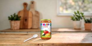 HiPP Pasta Bambini Rigatoni Napoli Bio-Glas auf Holztisch mit Löffel in heller, gemütlicher Küche