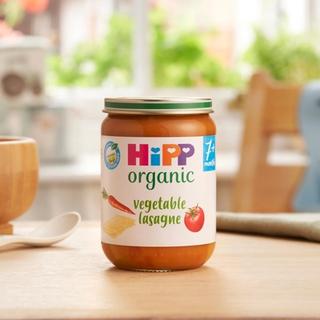 HiPP Organic Vegetable Lasagne on a dining table next to a bowl and spoon
