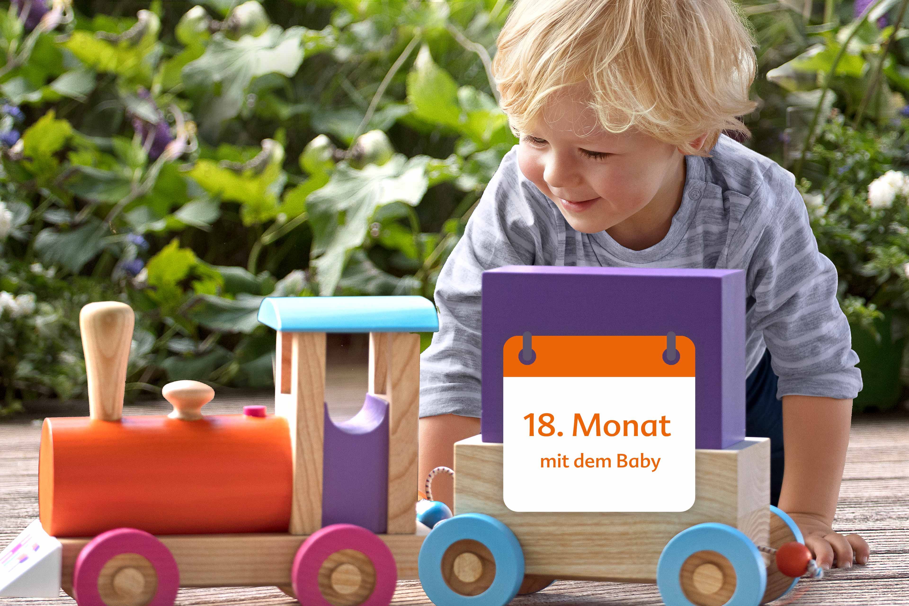 Ein kleines Kind, vermutlich ein Baby, spielt mit einem Holzspielzeug.