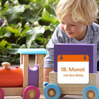 Ein kleines Kind, vermutlich ein Baby, spielt mit einem Holzspielzeug.