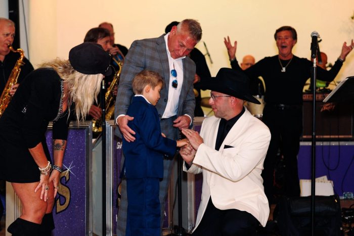 A young guest receives a gift on stage