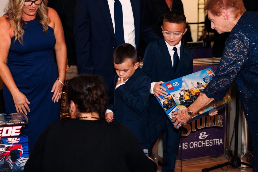 A boy opens a gift at the gala