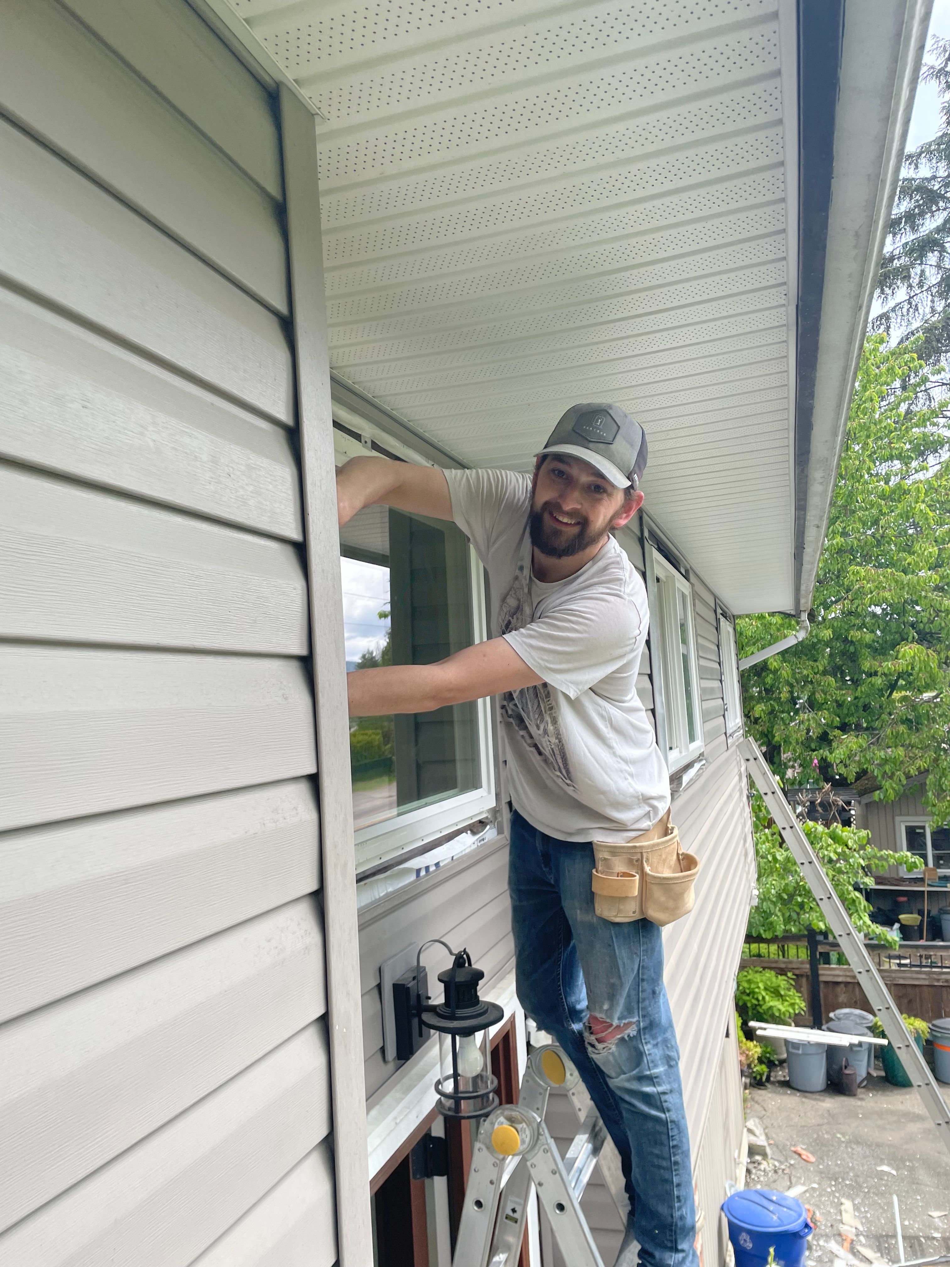 Drew Guthrie working the head flashing on a second-story dual-pane vinyl window install
