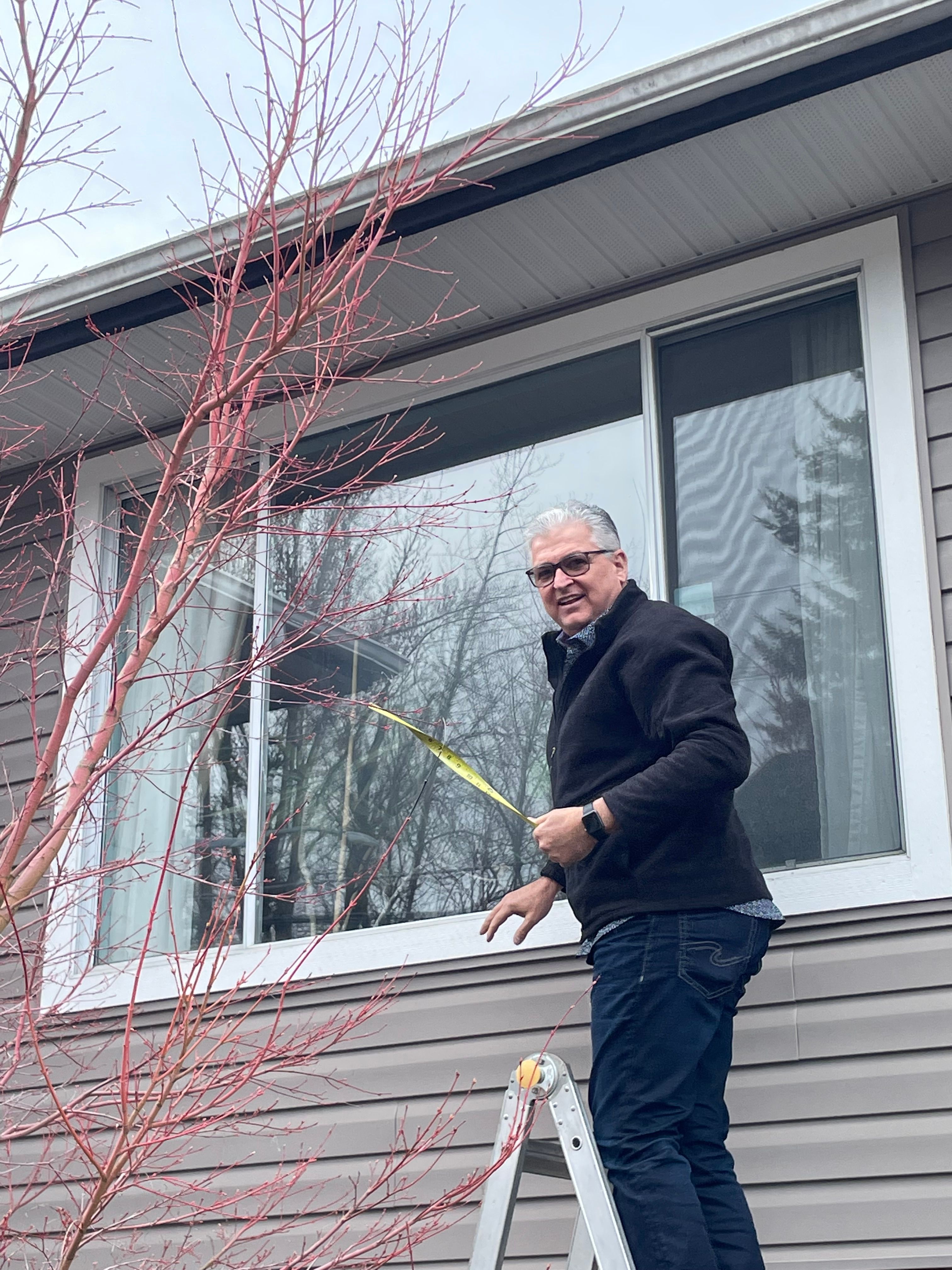 Drew Guthrie finishing the trim and seal on a dual-pane vinyl window install