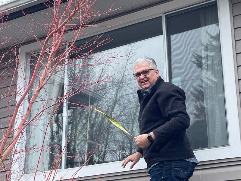 Drew Guthrie finishing the trim and seal on a dual-pane vinyl window install