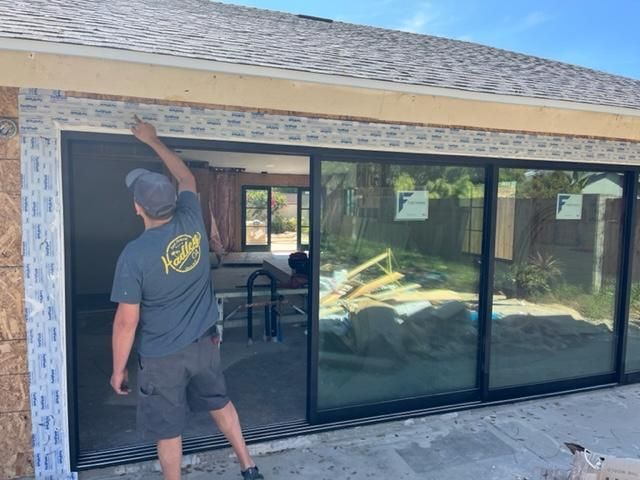 Drew Guthrie aligning the head jamb on a 4-panel multi-track sliding glass door at a new-construction Temecula home