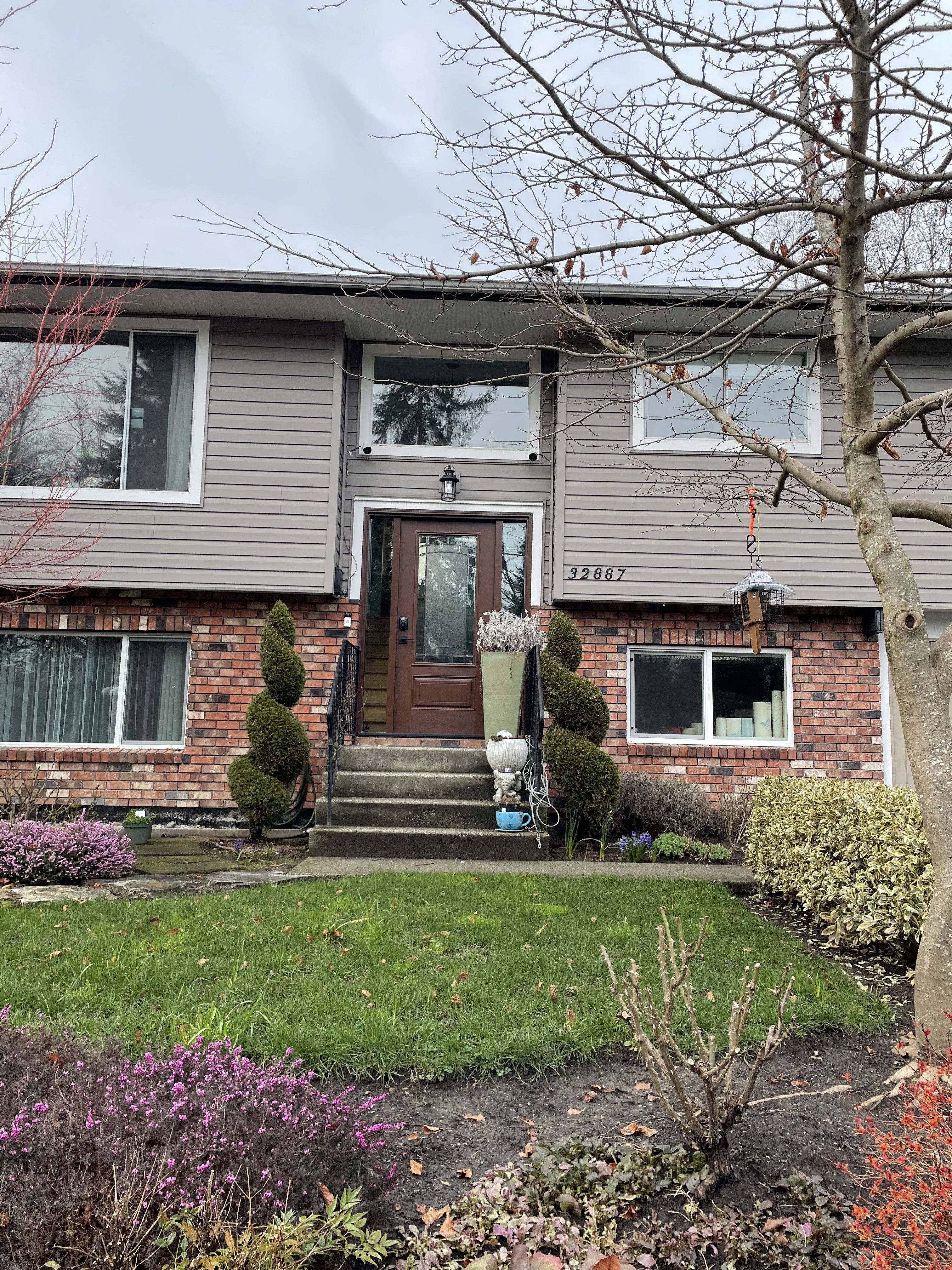 Fiberglass entry door with transom window installed on a two-story home