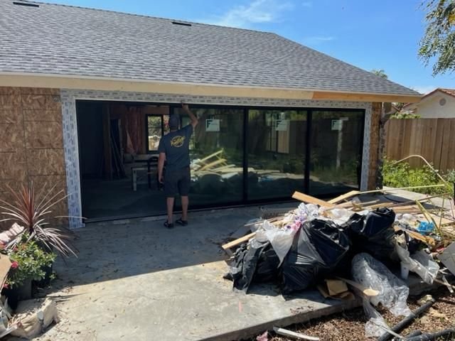 Drew Guthrie inspecting a 3-panel multi-track sliding glass door fresh-installed on a single-story Temecula home