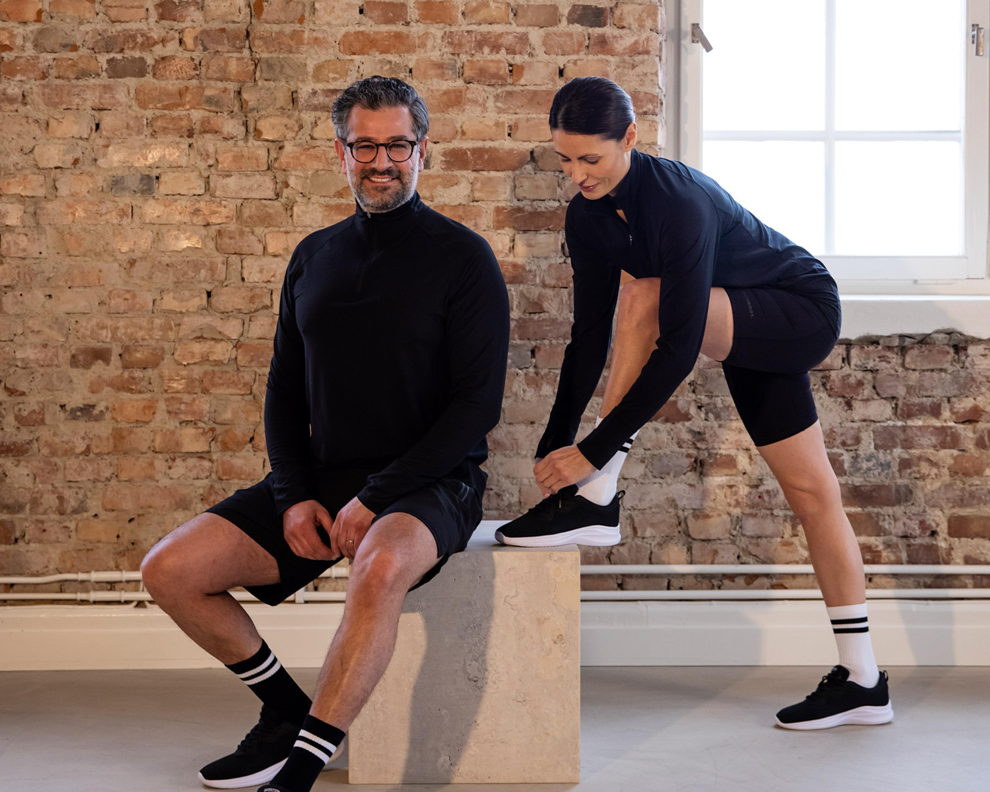 Man och kvinna i svarta träningskläder från Newbody Family