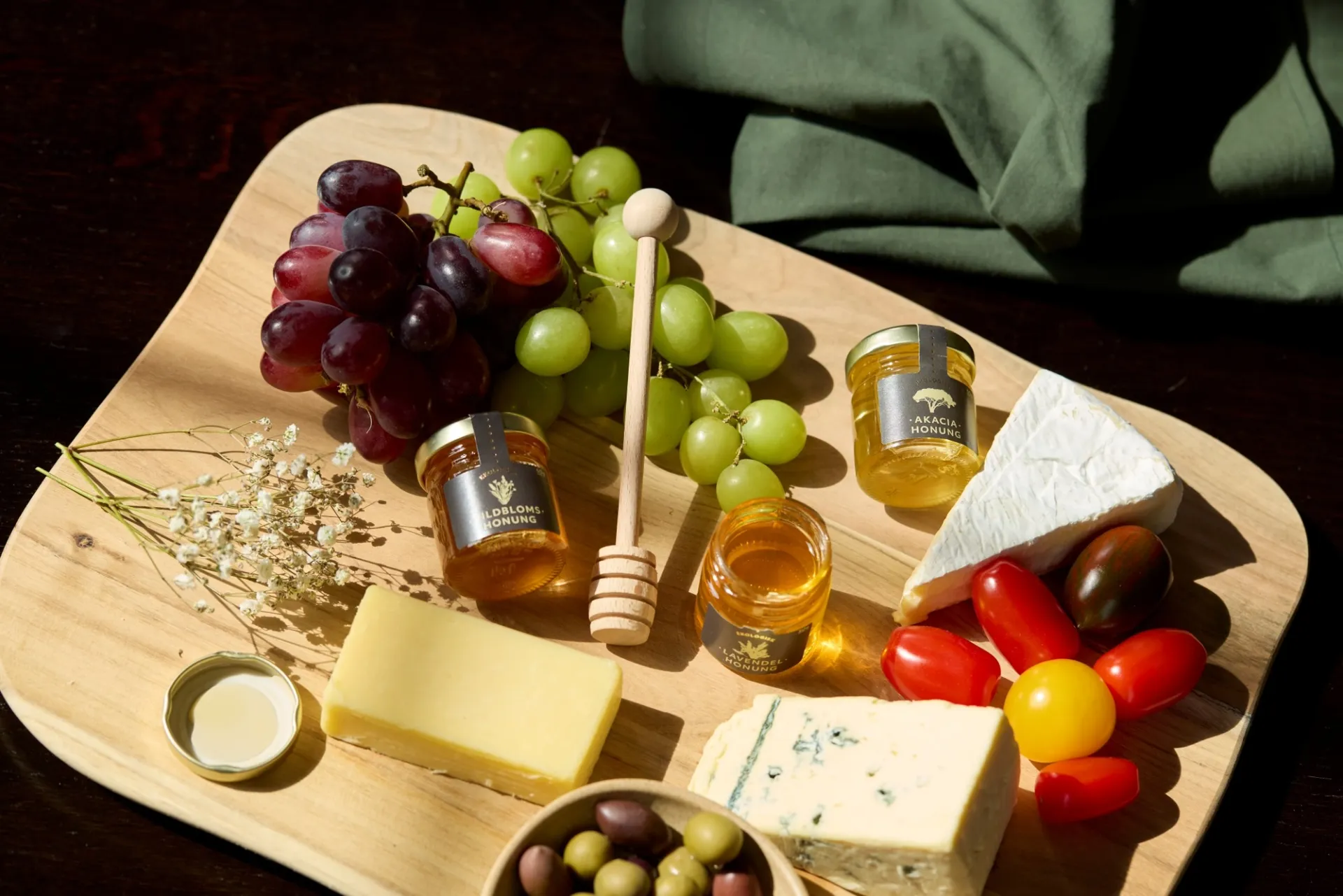 En bricka med honung, ostar, vindruvor och andra godsaker