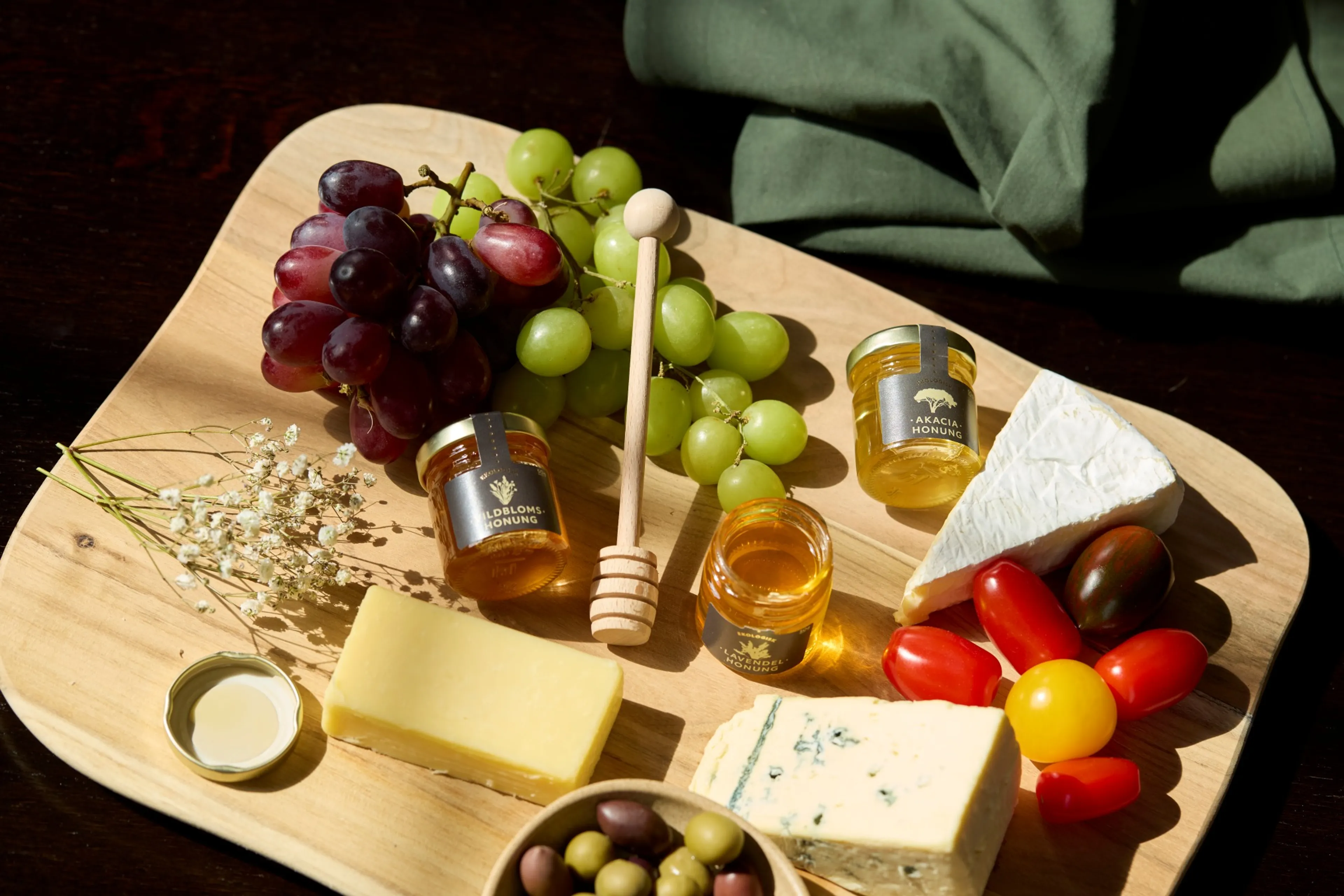 En bricka med honung, ostar, vindruvor och andra godsaker