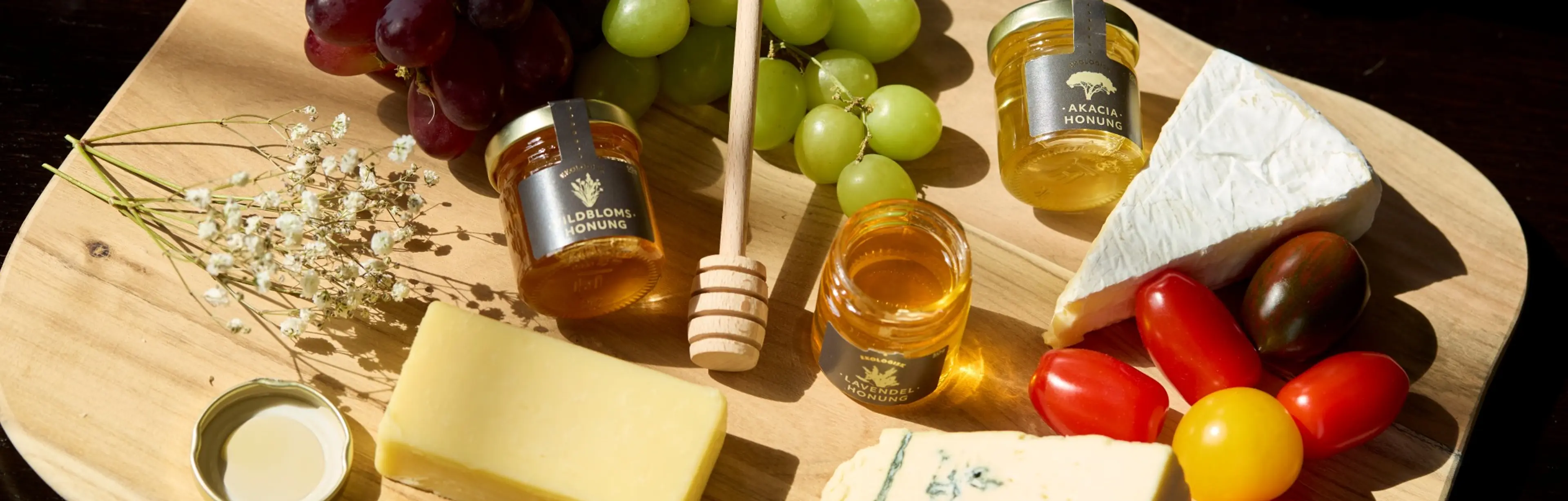 En bricka med honung, ostar, vindruvor och andra godsaker
