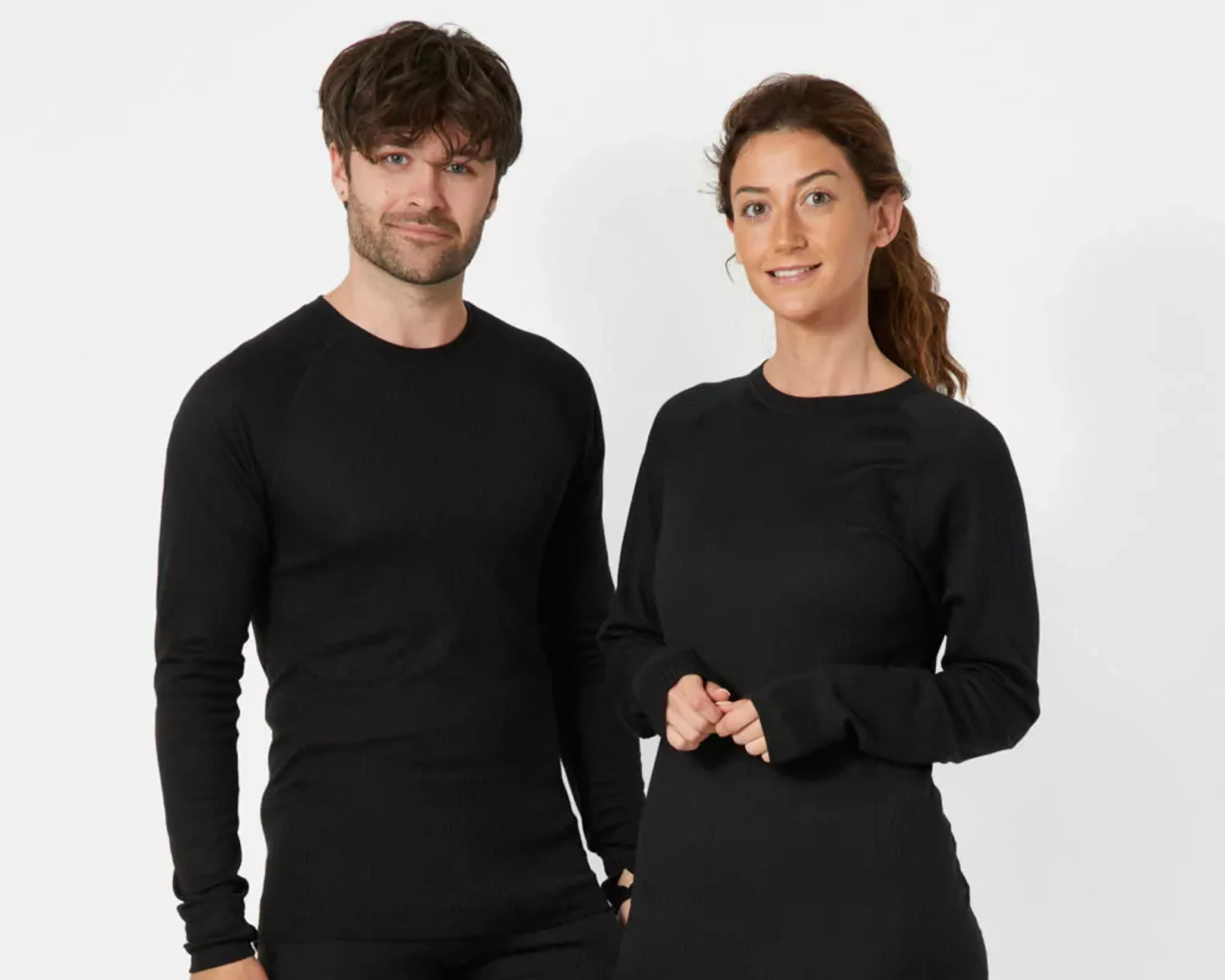 Två personer bär svarta, långärmade basplagg i en mjuk och följsam modell. Kläderna har ett enkelt och stilrent uttryck, anpassade för både vardag och aktivitet.