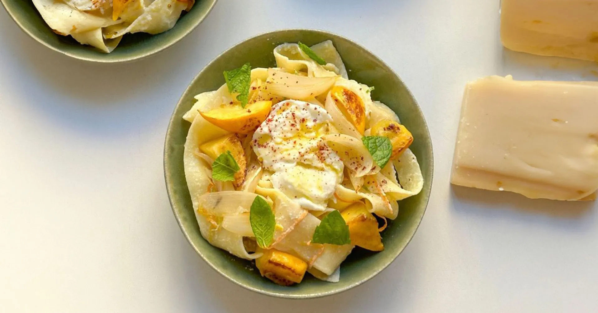 Gräddig pappardelle med citronbitar, karamelliserad lök och färska myntablad. En fräsch komposition med en touch av kryddor.